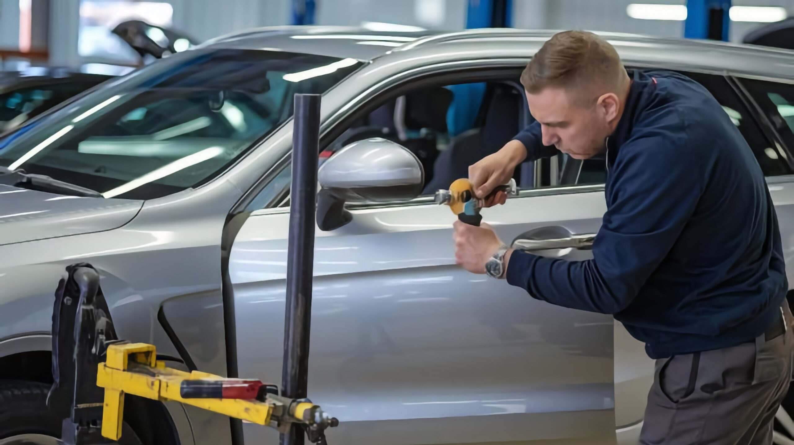 Paintless Dent Repair tech working on car door
