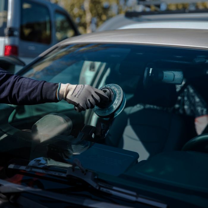 Technician with glove replacing windshield - auto glass repair - higgins body and paint